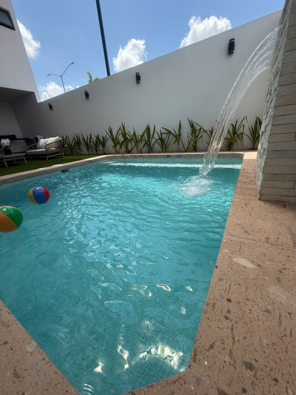 Alberca residencial con agua clara y cascada atendida por Picmas
